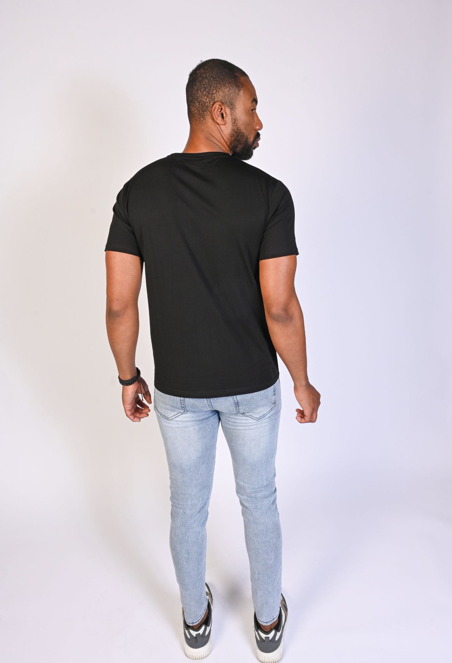 Back view of model wearing a black Clay & Ash WeaveForm T-shirt, crafted from organic cotton for a clean, sleek fit. Discover eco-friendly style with a perfect balance of comfort and durability