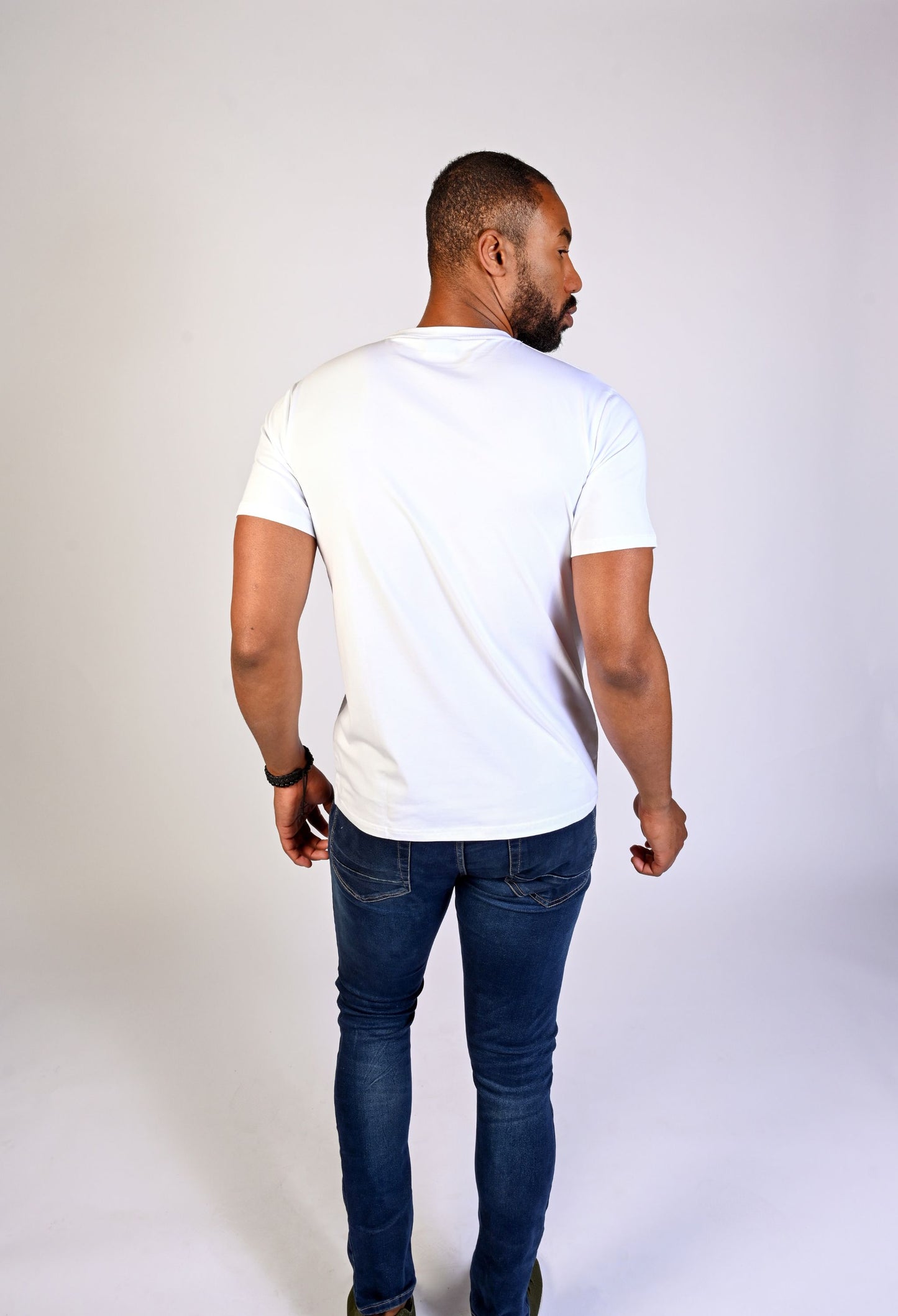 Back view of model in a white Clay & Ash organic cotton WeaveForm T-shirt, highlighting the tailored fit made from sustainable materials. Experience comfort and conscious style