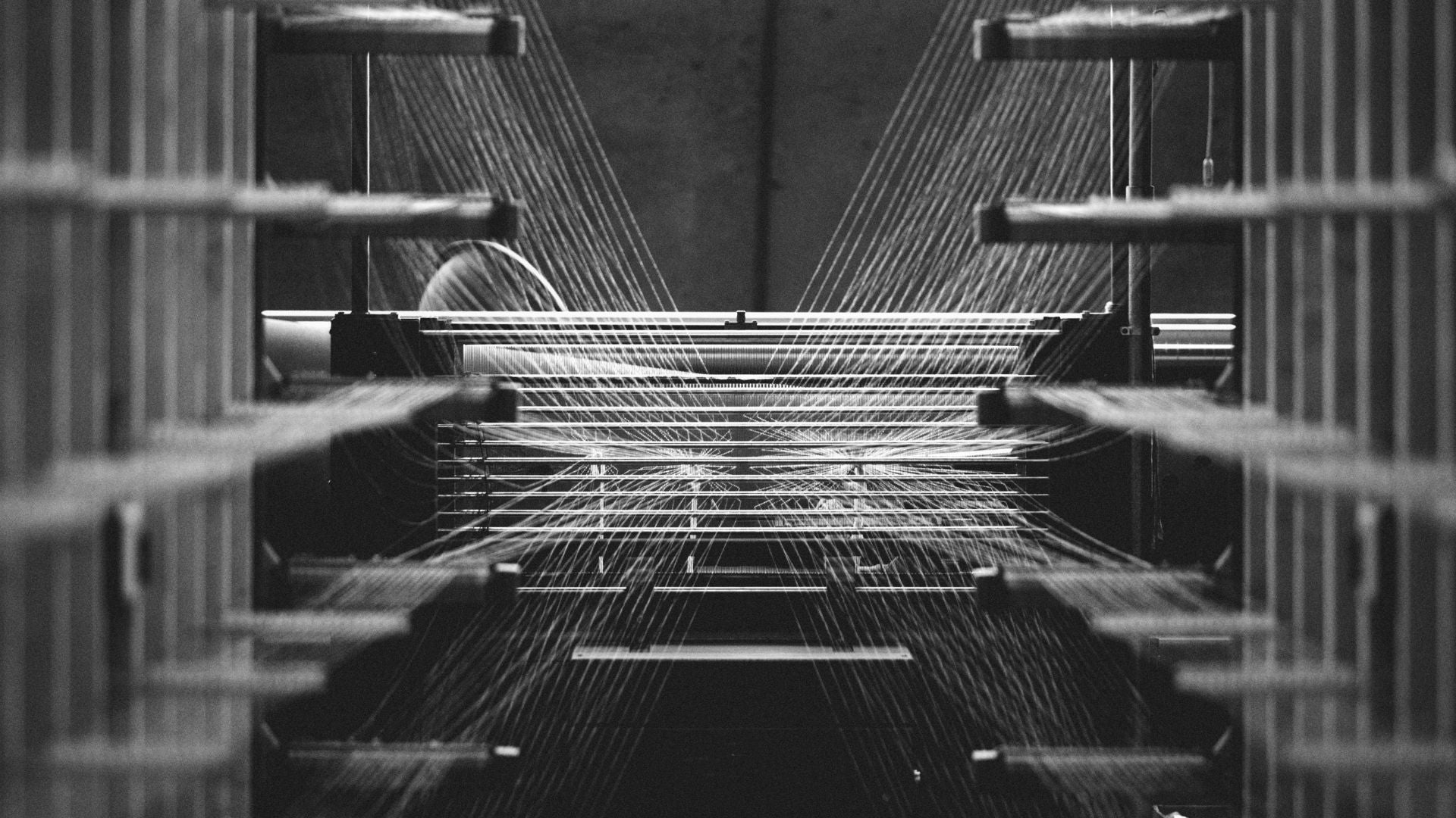 Close-up of weaving machinery in action, illustrating the precision and craftsmanship behind the fabric used in Clay & Ash T-shirts.